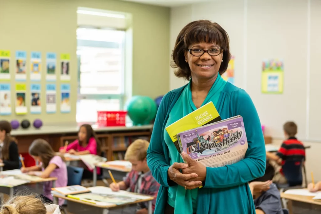 Teacher holds SW materials scaled 1