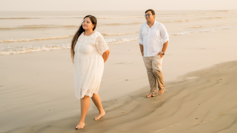 man and woman walking on the beach